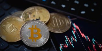 Gold Bitcoin and Ethereum cryptocurrency coins with candle stick graph chart, laptop keyboard, and digital background.
